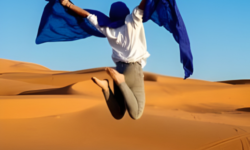 Traveler jumping in the Sahara desert dunes during a private Morocco tour